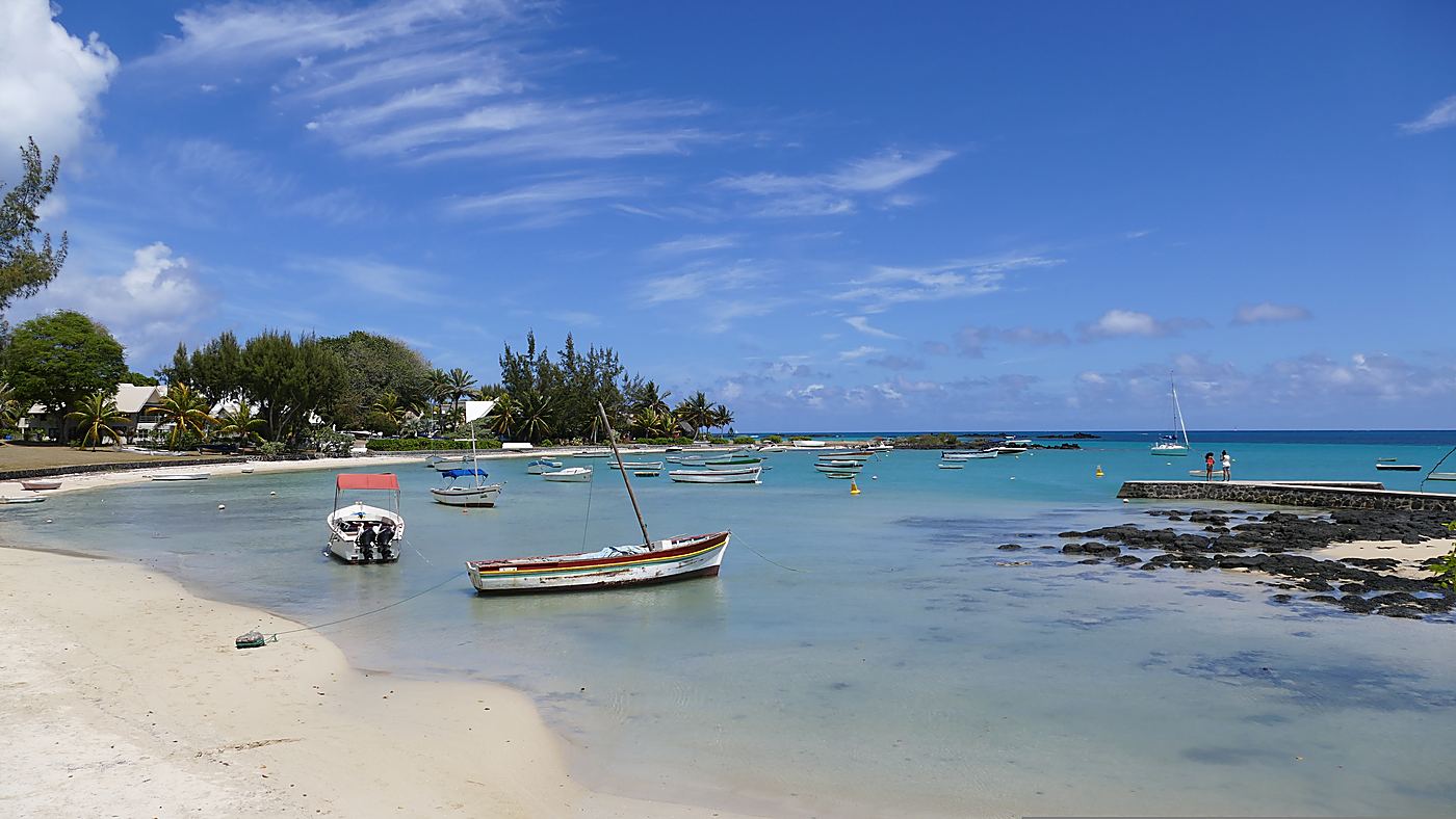 Pirogues de pêche au mouillage dans la baie et digue de basalte, au nord de l’île Maurice